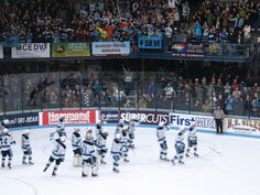 a hockey game is being played on an ice rink with fans in the bleachers