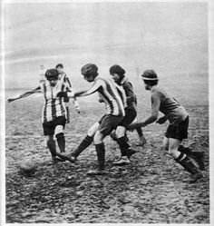 an old black and white photo of men playing soccer