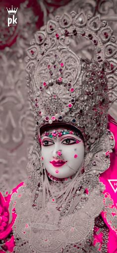 a woman in white and pink makeup is wearing a headdress with beads on it