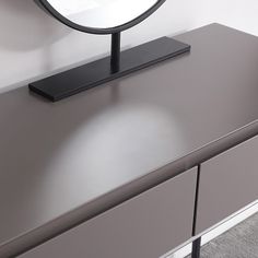 a round mirror sitting on top of a dresser