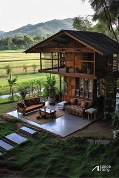 an outdoor living area with couches and tables in front of a large grassy field