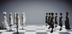 a group of mannequins standing on top of a checkered floor next to each other