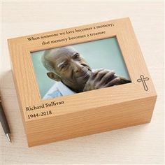 a small wooden box with a photo on it and a pen next to it that says, when someone we love becomes memory, this memory become a treasure