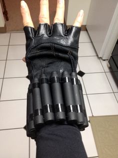 a person wearing black gloves and holding up their fingers