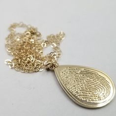 "All orders over $700 will receive a FREE sterling silver memorial fingerprint oval pendant mounted on an 18 inch sterling silver necklace. These pendants serve as a wonderful memorials, beautifully shaped in a meaningful teardrop design. his, the highest quality 10k solid gold, will remain maintenance free nearly to the level of 14k. You will have the piece of mind knowing the quality of the material and workmanship put into this pendant is at the highest quality level achievable. Every piece m Teardrop 14k Stamped Jewelry As Gift, Gold Teardrop Jewelry Stamped 14k, Elegant Laser Engraved Pendant Jewelry, Elegant Laser Engraved Necklaces For Keepsake, 14k Stamped Teardrop Jewelry Gift, Teardrop Shaped 14k Stamped Jewelry Gift, Keepsake Gold Stamped Jewelry, Elegant Stamped Jewelry For Memorial, Elegant Yellow Gold Necklace With Laser Engraving