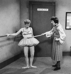 an old photo of two ballerinas pulling each other's strings with their hands