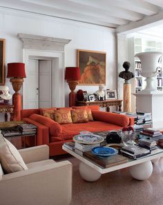 a living room filled with furniture and paintings on the wall next to a fire place