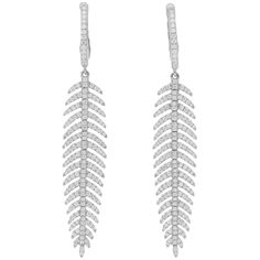 A gorgeous pair of articulated feather diamond drop earrings set in 18k white gold. Each earring depicts a beautiful feather which is articulated and claw-set throughout with round brilliant-cut diamonds. Each feather hangs elegantly from a similarly-set diamond hoop, which is fitted with a post and hinged click-shut fitting. What makes these earrings so unique and chic is the movement which allows them to glimmer and float so remarkably, moving and bending at each segment, catching the light at Elegant Feather Drop Earrings, Elegant Silver Feather Earrings, Diamond Drops, Feather Earrings, Diamond Drop Earrings, Round Brilliant Cut Diamond, Earrings Set, Or Rose, Earring Set