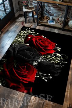 two red roses on a black rug in a room with wooden floors and windows,