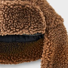 Take on the winter season in style with this Polyester All Over Faux Shearling Trapper Hat from Goodfellow & Co™. Made from a heavyweight woven fabric and filling, this faux shearling trapper hat offers your head and ears all-day cozy comfort. Designed with a chinstrap hook-and-loop fastener for a snug fit, it makes a standout addition to your collection of winterwear. Goodfellow & Co™: Feel good in what you wear, anywhere. Brown Hat With Plush Lining For Cold Weather, Winter Brown Hats With Plush Lining, Fall Hats With Faux Fur Lining, Faux Fur Hat For Fall, Fall Faux Fur Hat With Lining, Mink Color Hat With Faux Fur Lining For Winter, Mink Colored Winter Hat With Faux Fur Lining, Brown Winter Hat With Faux Fur Lining, Faux Fur Hats With Plush Lining For Cold Weather