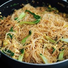 noodles and vegetables being cooked in a wok