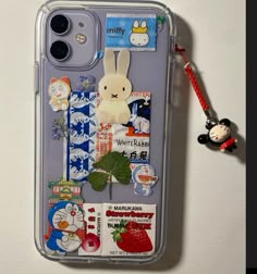 an iphone case with some stickers on it and a keychain attached to the back