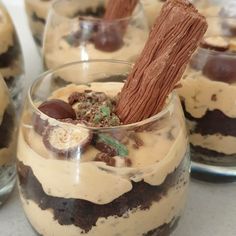 three desserts in glass cups with chocolate and candy