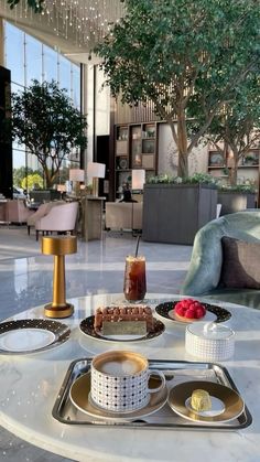 a table topped with cakes and desserts next to a couch in a living room