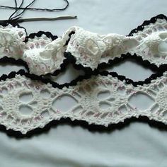 two crocheted garters are laying next to a pair of scissors