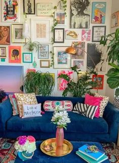 a living room filled with lots of pictures on the wall and furniture in front of it