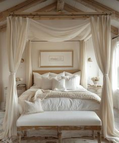 a bed with white sheets and pillows in a room