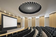 an empty auditorium with rows of chairs and a projector screen