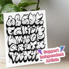 a card with the words support independent artists written in black and white on it next to a potted plant