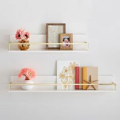 two white shelves with flowers and pictures on them