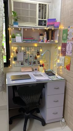 a desk with a computer and some lights on it