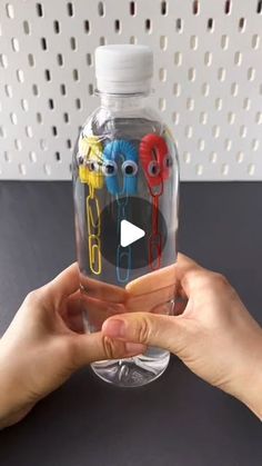 someone holding up a plastic bottle with cartoon characters on it