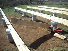 some wooden beams are laying on the ground in order to be constructed into an outdoor seating area