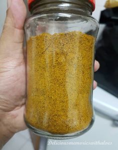 a person holding a jar filled with yellow sand