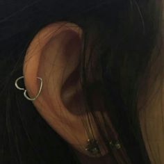 a woman's ear is shown with two metal hoops