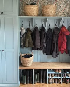 a coat rack filled with coats and shoes next to a wall mounted closet full of boots