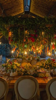 a long table with chairs and flowers on it in front of a decorated stage set for an event