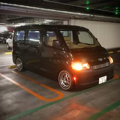 a small black van parked in a parking garage