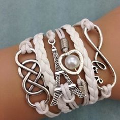 So Fun And Boho This Braided Rope Design Bracelet Features Charms Like The Eiffel Tower, Infinity Symbol And A Silver Tone Heart Encircling A Faux Pearl.Each Held In Place By This Lovely Braided Rope. Fun, Boho, Trendy Look With Denim Or Beachwear White Metal Charm Bracelet As A Gift, White Metal Charm Bracelet As Gift, White Metal Jewelry For Friendship, Casual White Metal Jewelry, Trendy White Metal Bracelets, Trendy Adjustable White Jewelry, White Bohemian Bracelets As Fashion Accessory, Casual White Adjustable Charm Bracelet, White Bohemian Bracelets Fashion Accessory