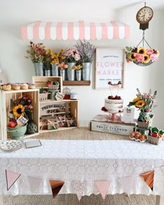 a table topped with lots of flowers next to a shelf filled with cakes and pies