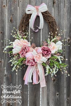 a wreath with flowers hanging on a wooden fence