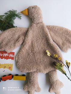 a stuffed bird is laying on the floor next to some toys and flowers in front of it