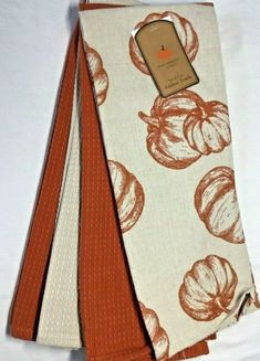 two orange and white napkins with a cell phone on top of one in front of the other