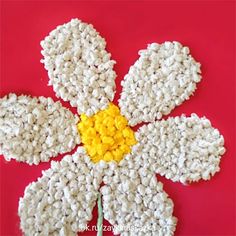 a flower made out of rice on a pink surface