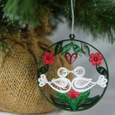 an ornament hanging from a christmas tree with red and green ornaments on it