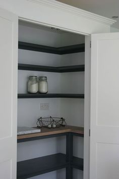 an open closet with shelves and jars on it