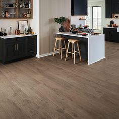 a kitchen with wooden floors and black cabinets