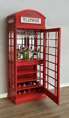 a red phone booth with wine bottles in it's display case on the floor