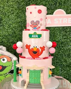 a pink cake with sesame street characters on it