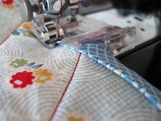 a close up of a sewing machine on a piece of fabric with flowered designs