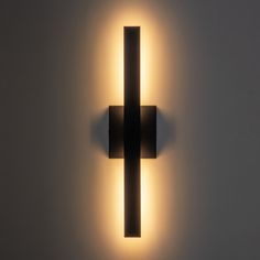 a wall light that is on the side of a wall with a cross in it