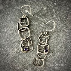 "These hand-forged solid 925 Sterling Silver earrings titled, \"Asymmetric Life\", feature faceted deep purple amethysts atop uniquely different left and right earrings.  This design is to remind the wearer that a little chaos and diversion from our original plan can still be lovely and cohesive when we look at our lives. Check out other Amethyst pieces in the shop while they last (Shown in the 2nd pic)! Weight per earring: 4.4 grams Delivered in a gift box with accompanying Healing Property Cards. Amethyst Healing properties: A protective stone that guards one from negative energy and psychic attacks. Accelerates the development of psychic abilities and intuition. Effective in overcoming addictions and compulsive behaviors, bringing self-awareness and healing. Silver Healing properties: A Modern Purple Sterling Silver Earrings, Purple Modern Sterling Silver Earrings, Amethyst Healing Properties, Earrings Inspiration, Sterling Silver Dangle Earrings, Metal Work, Dainty Earrings, 925 Sterling Silver Earrings, Healing Properties