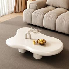 a white coffee table sitting on top of a carpeted floor next to a couch