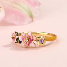 Transforming the iconic "Water Lilies" from Monet into an unexpected and artistic treasure, this beautifully detailed ring boasts charming lotuses in bright shades of enamel. The intricate flawless enamel work coupled with sparking stones, make this an eye-catching piece. Encapsulating peace and harmony, this intricately crafted ring looks beautiful worn alone or when layered in a stack. The stacking ring showcases the dreamlike play of light and shadow on the shimmering water surface. In Monet' Elegant Pink Enamel Ring, Elegant Adjustable Enamel Ring For Weddings, Adjustable Elegant Enamel Wedding Ring, Elegant Gold Enamel Flower Ring, Delicate Pink Flower Ring For Wedding, Pink Flower Enamel Ring For Wedding, Pink Flower Enamel Ring For Gift, Elegant Flower-shaped Enamel Wedding Ring, Elegant Flower Shaped Enamel Wedding Ring