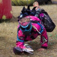 a person in pink and blue gear is bending over with their feet on the ground