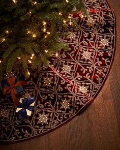 a christmas tree is on the floor next to a red rug